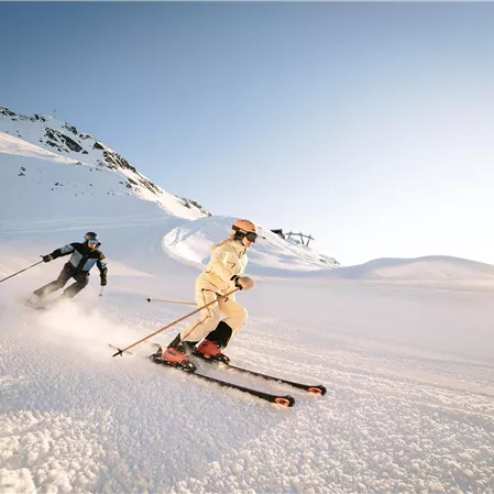 Zwei Skifahrer erleben Pistenspass im Hochzeiger Skigebiet